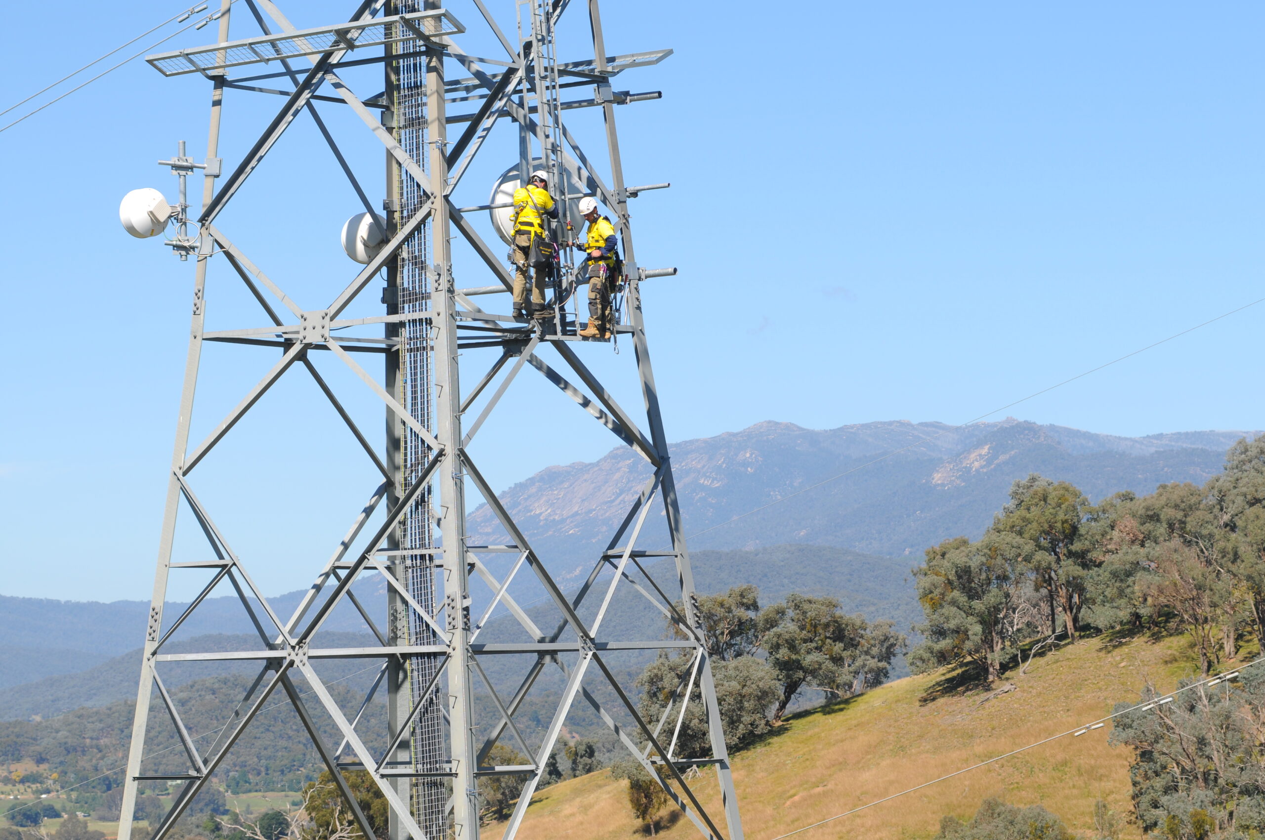 Colaborador con arnés trabajando en telecomunicaciones